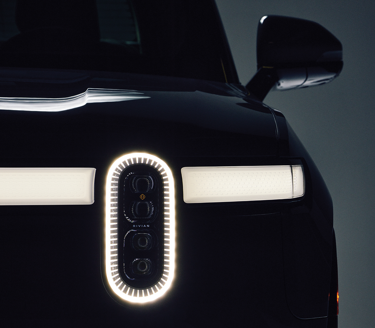 Closeup of Rivian R1T’s front headlight turned on  