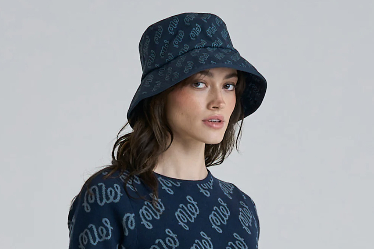 Model wearing a bucket hat and sweater by Malbon Sportwear designed by LA-based Stephen Malbon and his wife Erica. They bring a rebellious, disruptive style to golfwear with their 6-year-old line, Malbon. 