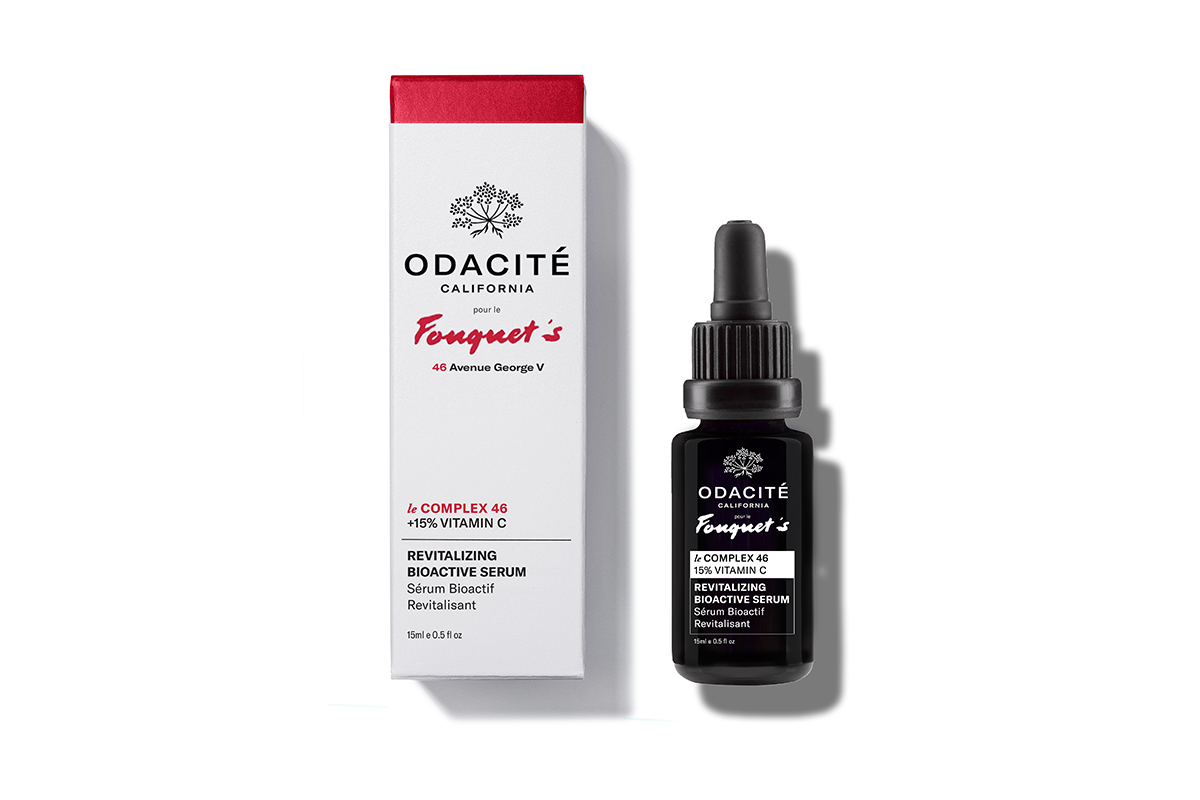 A small, black glass bottle of Odacité Fouquet Le Complexe serum on a white background. The bottle has a dropper cap and white text.
