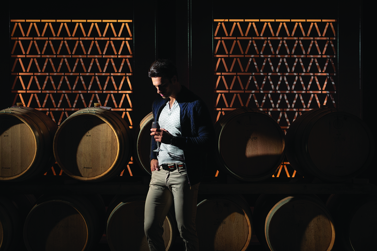 Man holding wine glass inside Castelfalfi wine cellar