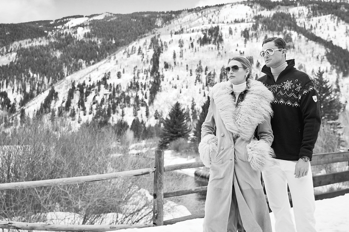 Fashionable couple standing outside near snowy Aspen mountains