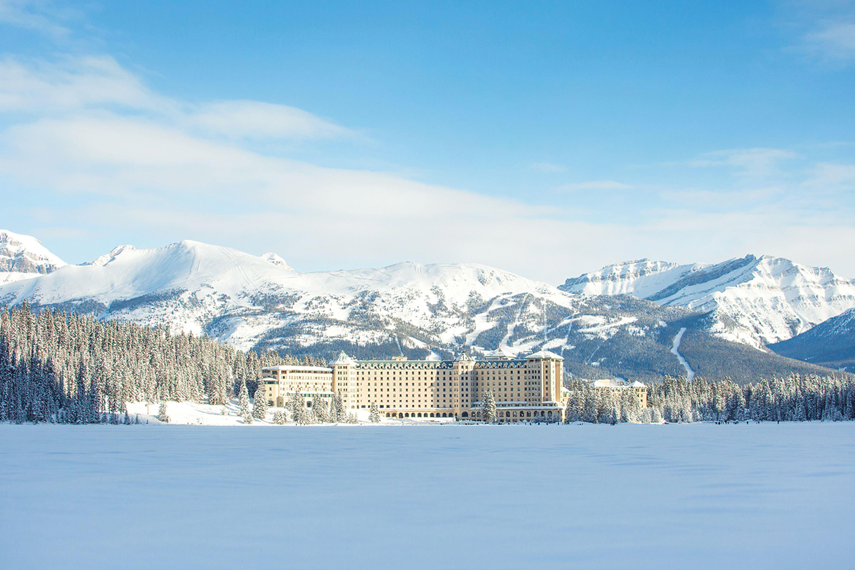 The Fairmont Chateau Lake Louise is perched on the shores of a frozen lake in Banff National Park. The grand mountain resort is nestled amidst pristine snow-capped peaks.