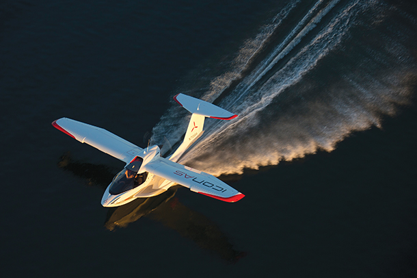 Top view of small, white sea plane with red trim detailing and a unique folding wing design. It has the words “Icon A5” on its wing. 