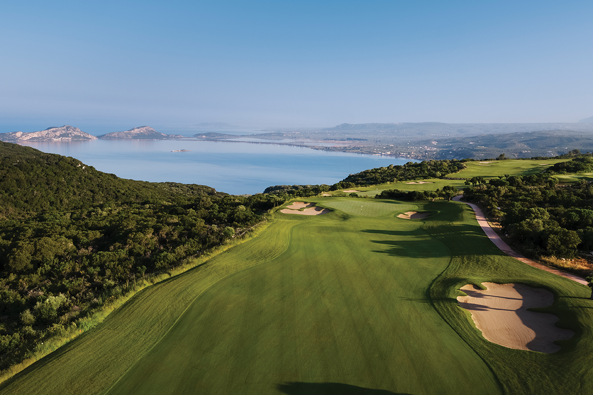 Golf fairway with bunkers surrounded by lush trees and landscaping that overlooks Bay of Navarino.