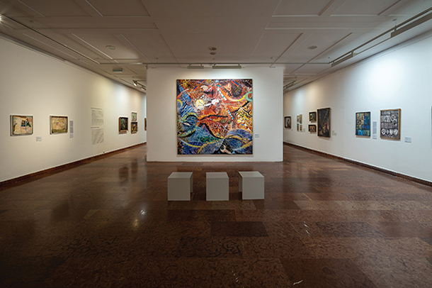 Large-sized, colorful, abstract artwork displayed on a white gallery wall