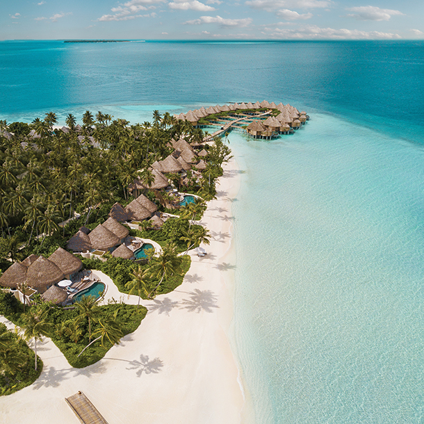 Aerial view of luxurious beach and overwater houses on a secluded island coastline
