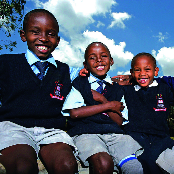 Group of young African boys wearing school uniforms posing and sitting together