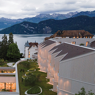 Hotel, spa and wellness center surrounded by gardens, Lake Lucerne and Swiss Alps in the background
