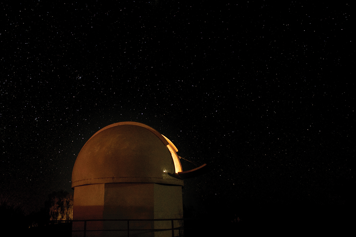 Closeup of observatory dome with stars and night sky in the background