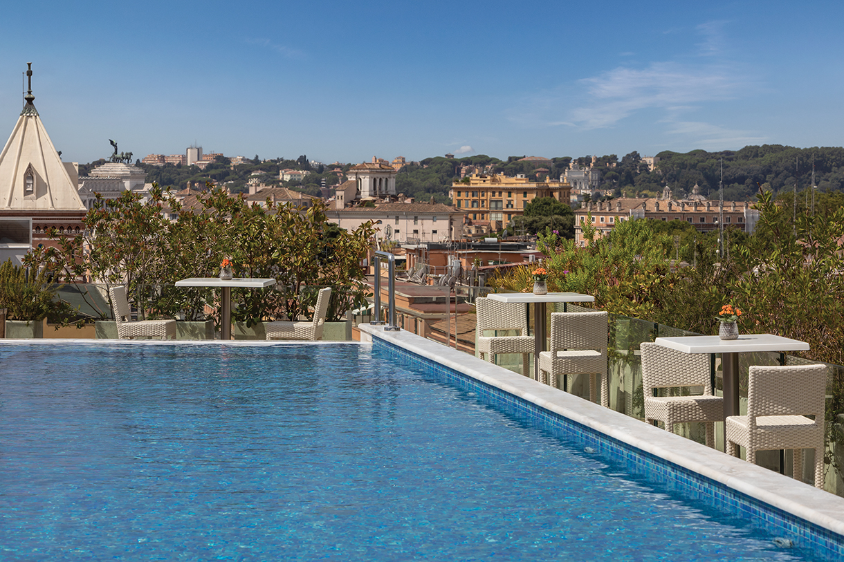 Roman hotel outdoor pool with view of Rome skyline