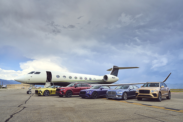 Bentley cars lined up next to private jet on tarmac of airfield