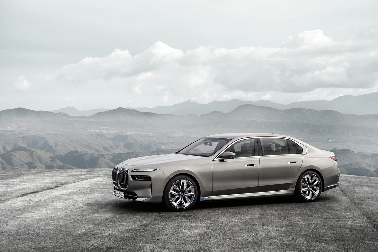 Side view of silver BMW i7 xDrive60 with mountains in the background