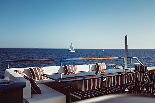 The ArtExplorer is a luxurious yacht that is perfect for entertaining guests. The deck of a catamaran made of teak and has a spacious dining table with seating for many guests. The table is made of glass and has a beautiful view of the sea.