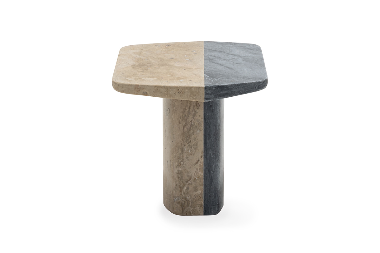  A small, rectangular side table with a bi-colored top made of beige and gray marble. The table has a thick, cylindrical leg made of the same marble.