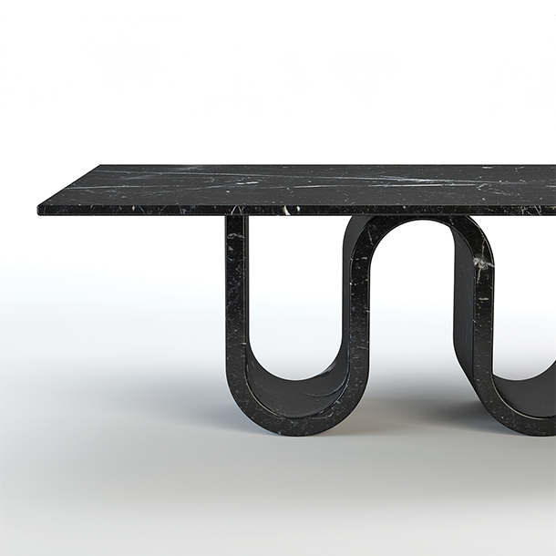 A close-up of a black marble dining table with a unique, wavy base.