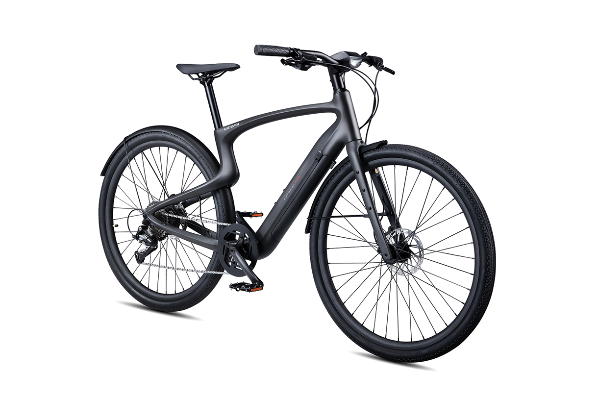  A black electric bike with a carbon fiber frame and thick tires. It has a step-through frame and a front light.