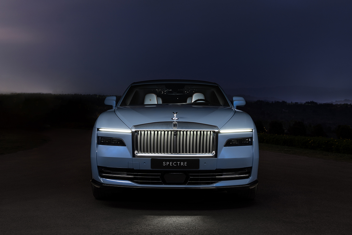  A front view of a blue Rolls-Royce Spectre at night