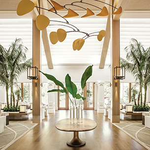 A spacious and inviting lobby at Sensei Lanai, featuring a stunning mobile hanging from the ceiling and a stylish interior design with natural light.