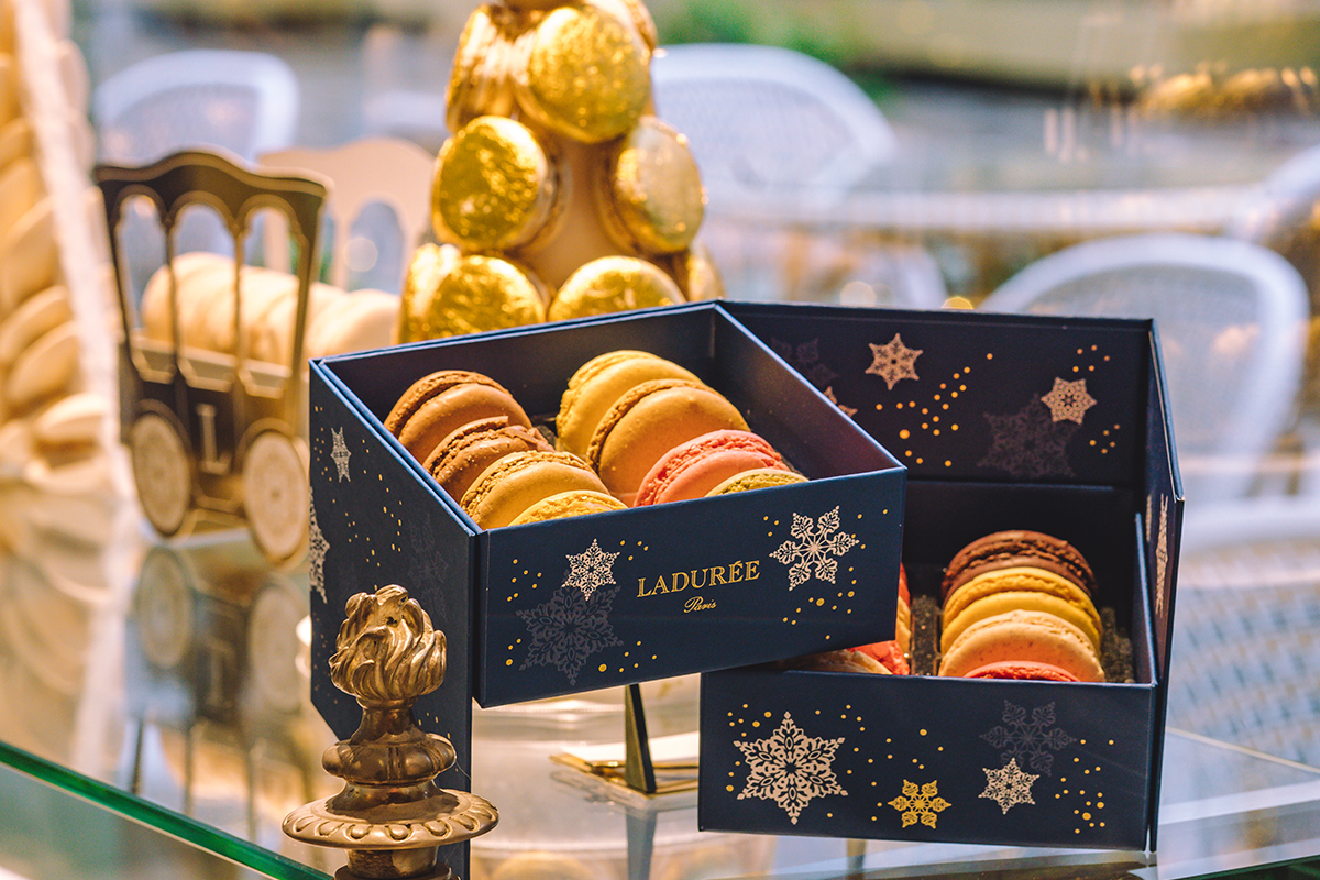 A box of Parisian Macarons from Ladurée in a window display. An example of local culinary experts the Bicester Collection collaborates with to offer exquisite dining experiences.
