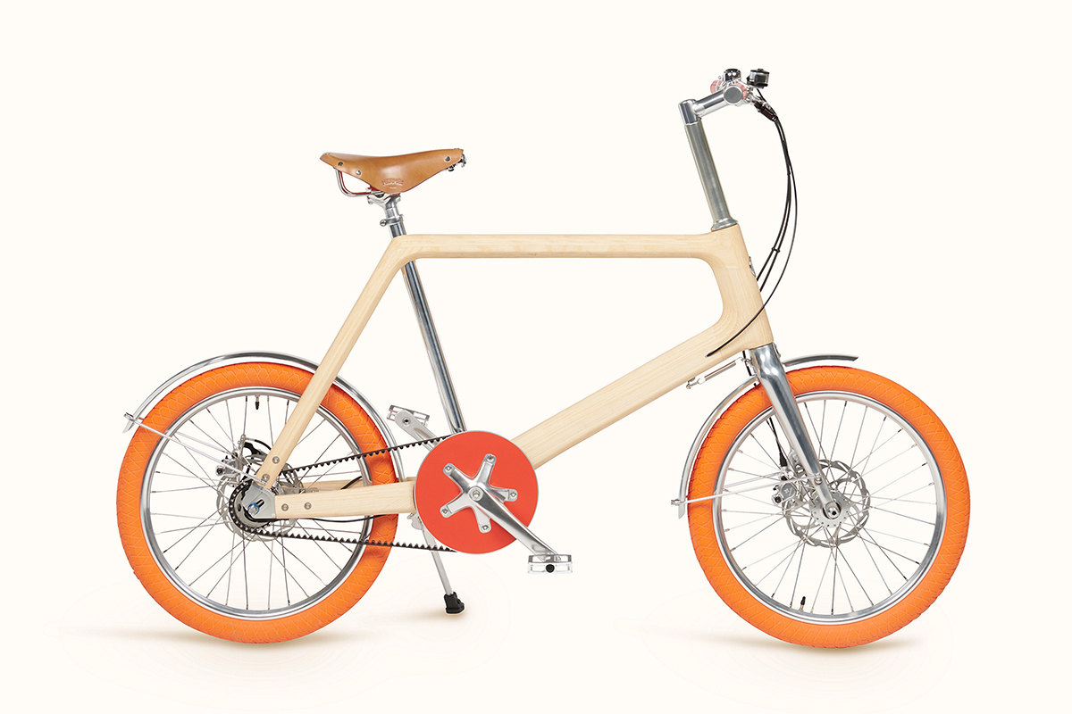 Urban and lightweight, cream-colored pedal bicycle with 4 speed gears, leather saddle, and orange wheels. Light is integrated into the handlebars and seat post. 