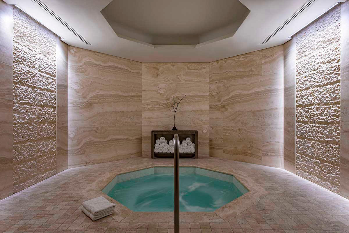 A luxurious indoor hot tub shaped as an octagon in a spacious calming atmosphere.