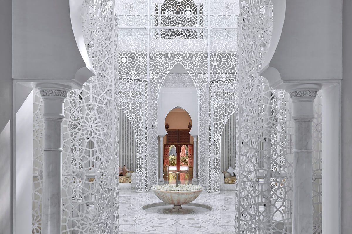 A beautiful and serene spa setting at the Royal Mansour in Morocco. The spa features exquisite Moroccan architecture, intricate tilework, and intricate carvings.