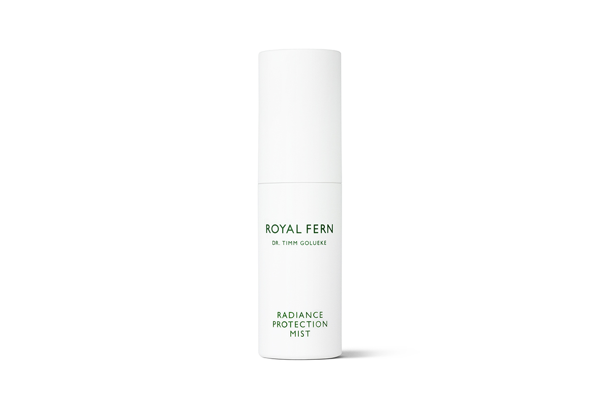A white bottle of Royal Fern Radiance Protection Mist, with the brand name and product name written in black letters. 