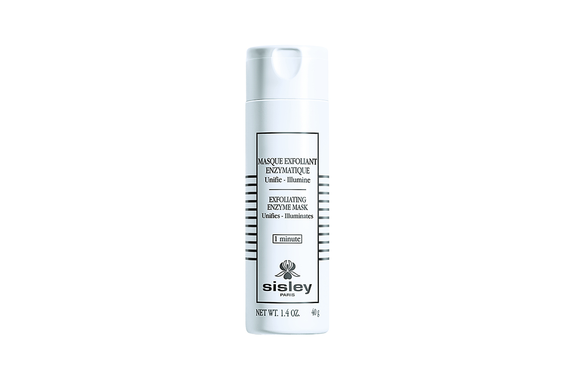 A white tube of Sisley Paris Exfoliating Enzyme Mask, with the brand name and product name written in black letters. The tube is sitting on a white background.