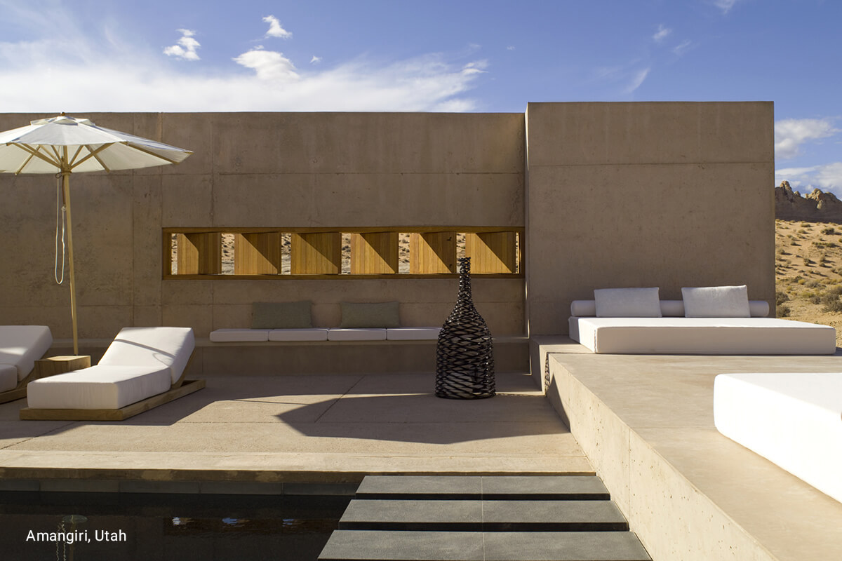 A relaxing pool area amidst stunning landscape of a desert canyon in the American Southwest with a modern architectural structure made of concrete. 