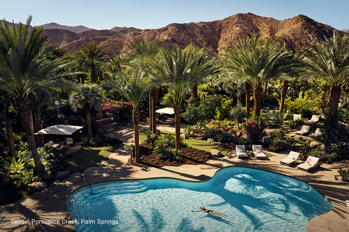 A serene outdoor setting with swimming pool at Sensei Porcupine Creek in Rancho Mirage, California, with a beautiful desert landscape in the background.