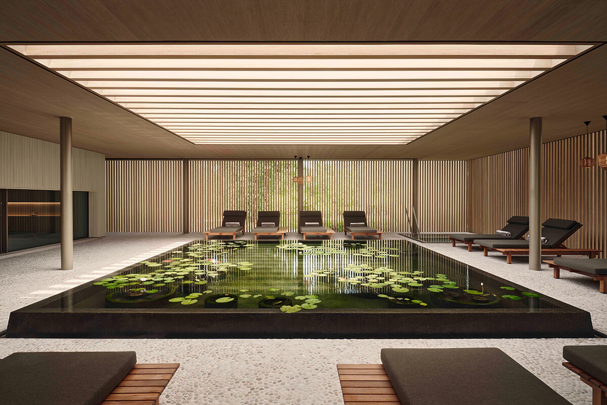 A stunning tranquil indoor pool filled lily pads and surrounded with lounge chaises. 