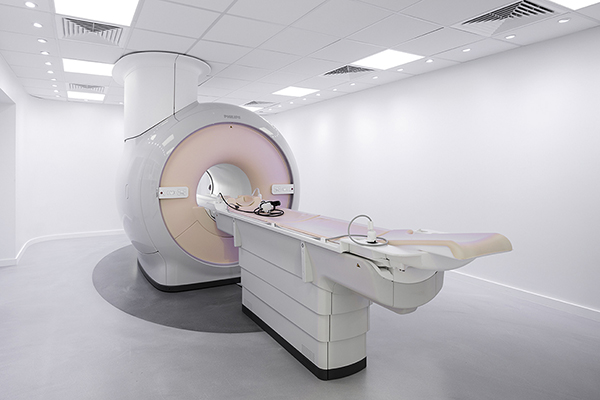 A full-body MRI machine at Preventicum, a wellness retreat located in London, UK. The machine is large and cylindrical, with a white and silver exterior, and it is partially opened to reveal the inside. 