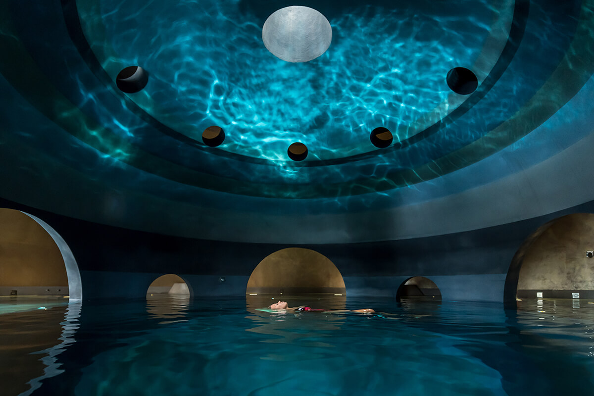 A woman floating in an indoor sphere pool at Euphoria Retreat.
