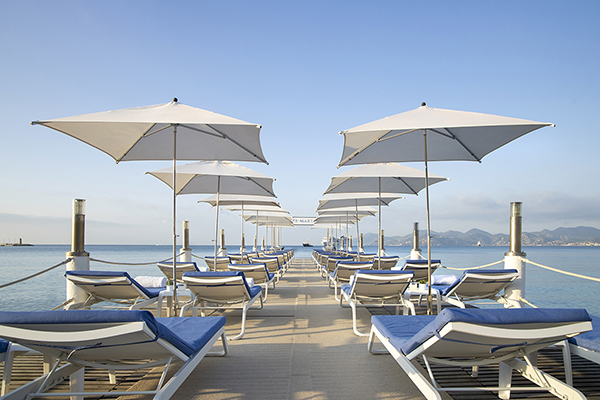 A private beach deck at the Hotel Martinez in Cannes, France. An iconic spot on the French Riviera. The image conveys a sense of glamour and sophistication, with a focus on the elegant setting of the Hotel Martinez and its luxurious spa experience.