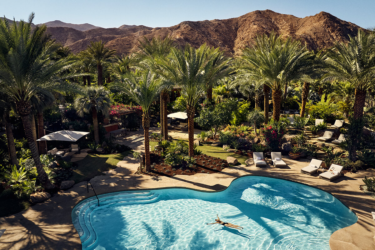 A serene outdoor setting with swimming pool at Sensei Porcupine Creek in Rancho Mirage, California, with a beautiful desert landscape in the background.