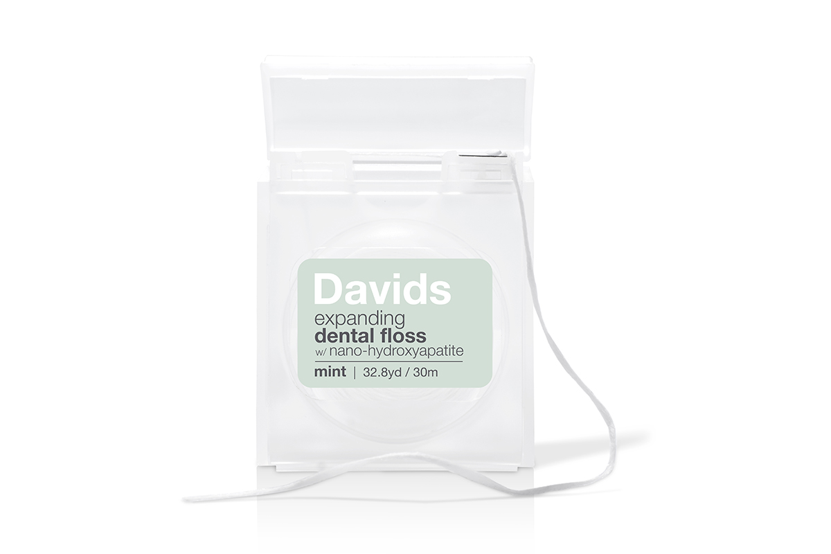 Davids Nano-Hydroxyapatite Expanding Dental Floss and Sensitive+Whitening Premium Peppermint Toothpaste on a white background.