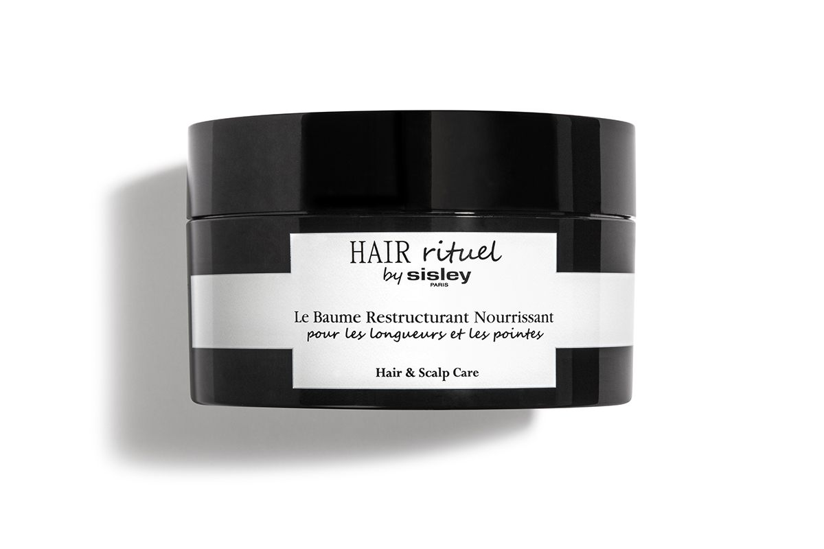 A black jar with a white stripe and label of Sisley Hair Rituel Restructuring Nourishing Balm for hair lengths and ends.