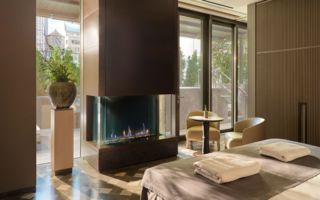 A luxurious room with a fireplace at the Aman Hotel in New York.
